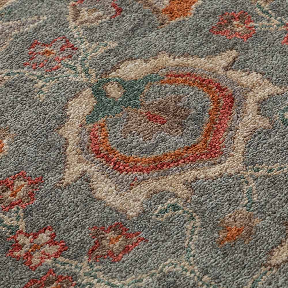 Close-up of a patterned rug with floral designs and a central circular design.
