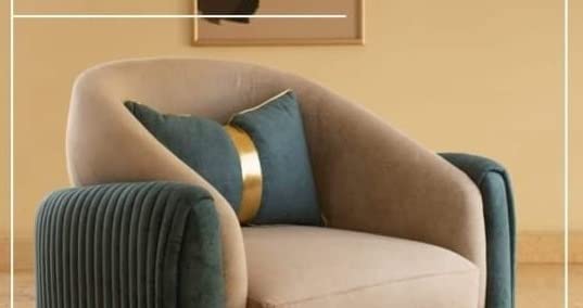 Beige armchair with green cushions against a beige wall