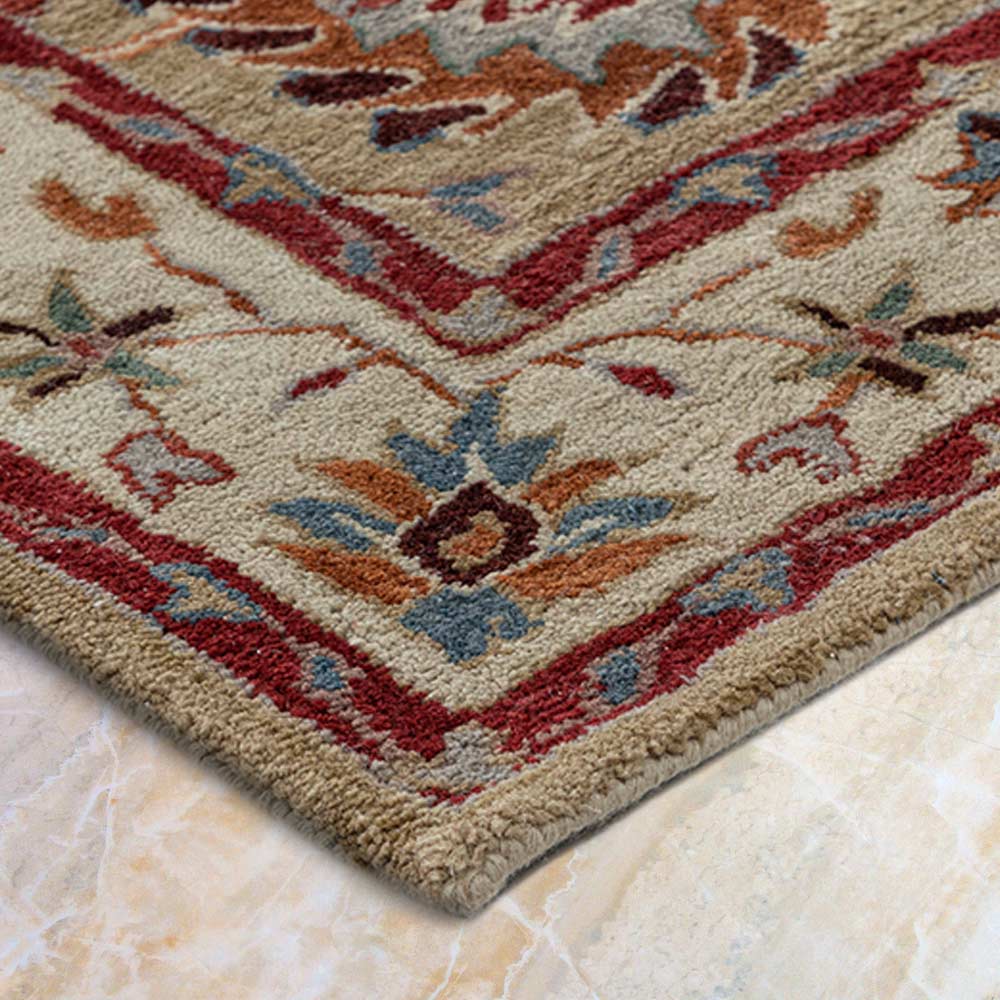 Close-up of a patterned rug with red, beige, and blue colors on a marble floor.
