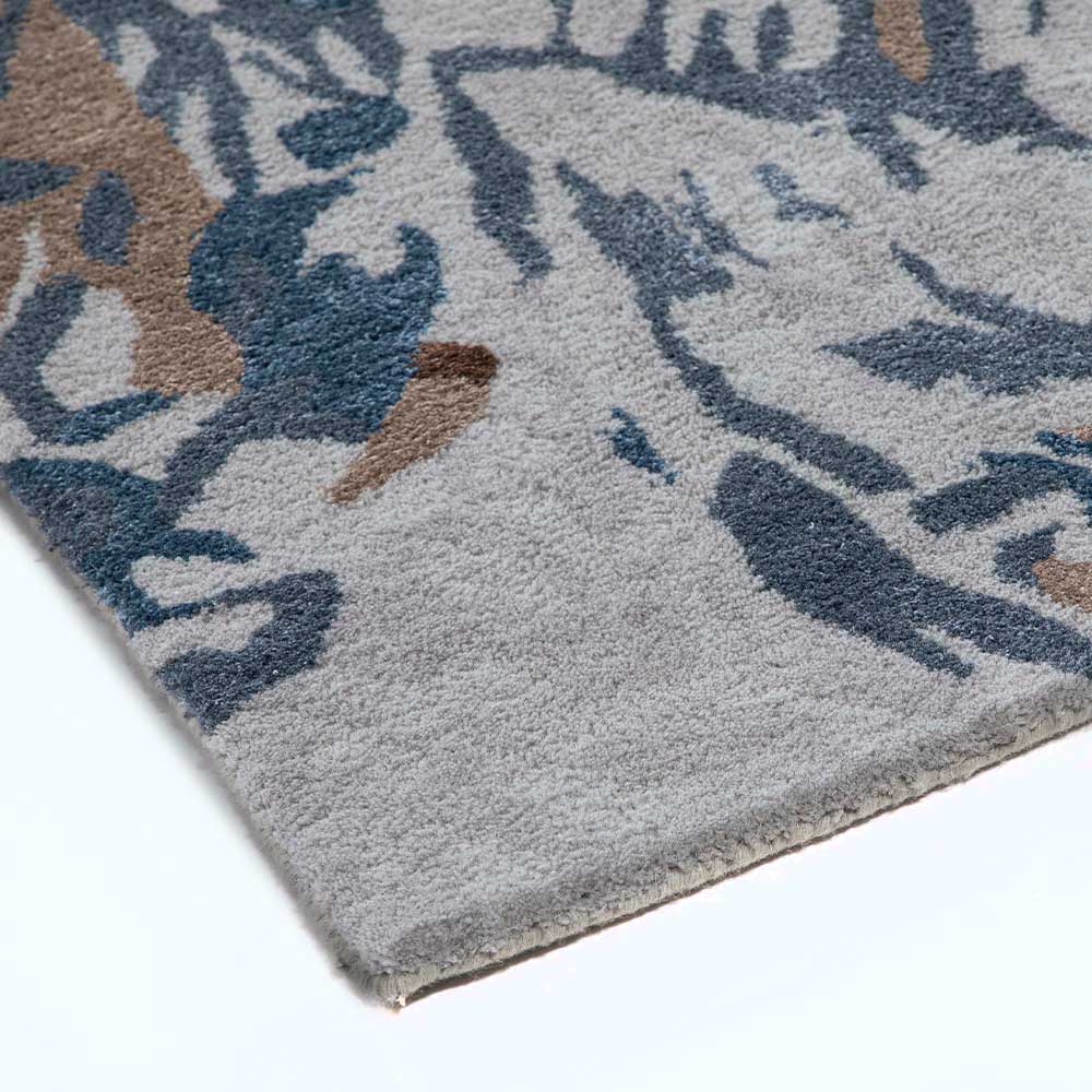Close-up of a patterned rug with blue, brown, and gray colors on a white background.