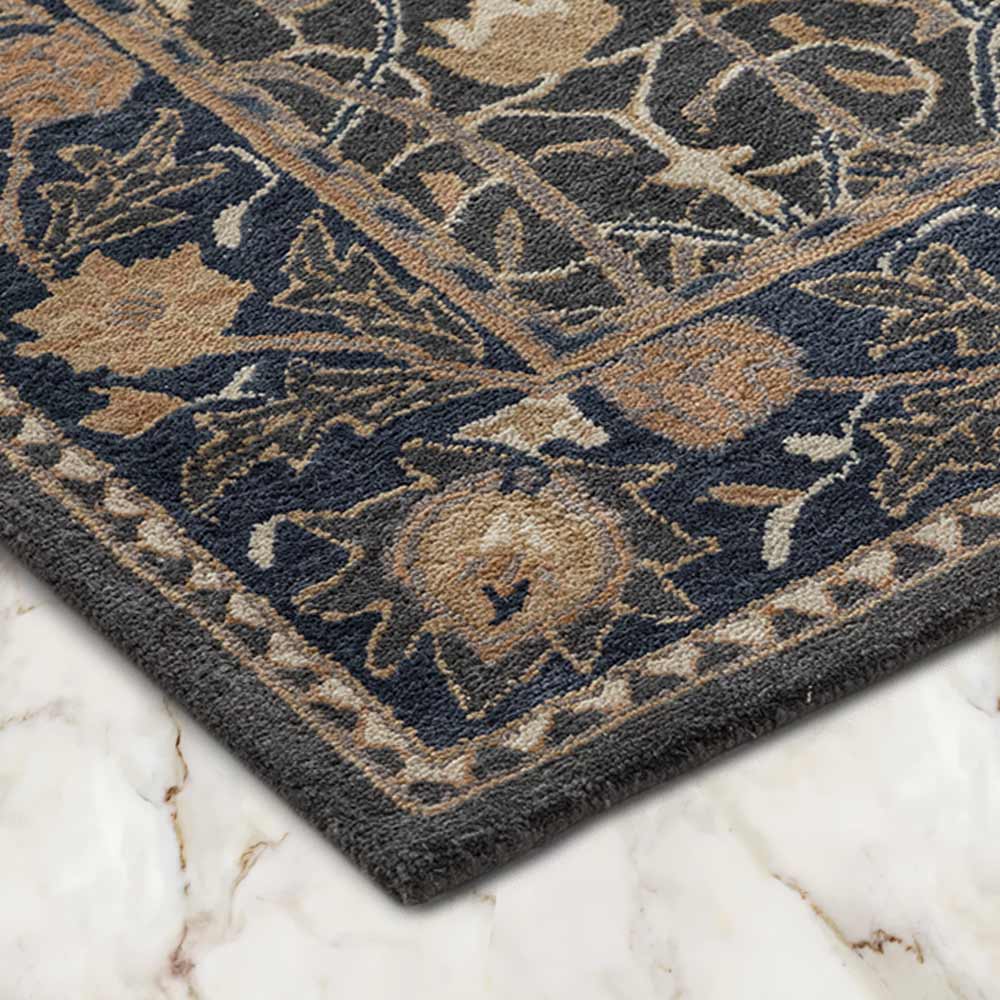 Close-up of a patterned rug with floral designs on a marble floor.