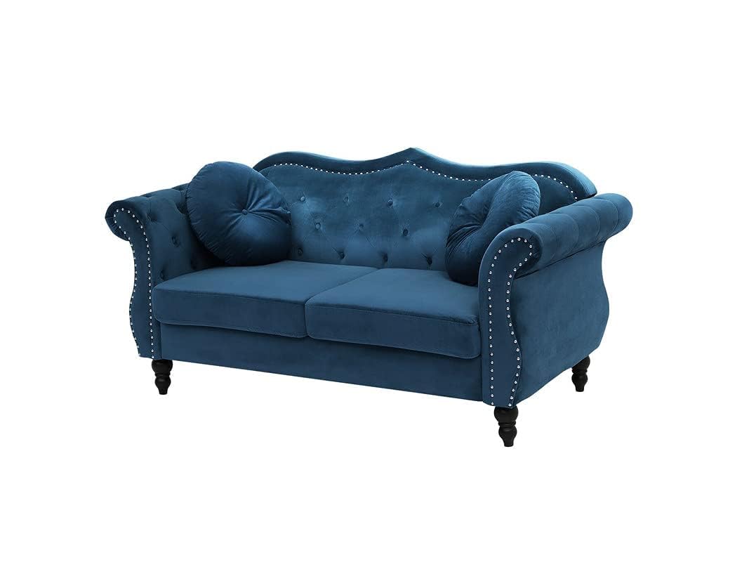 Blue velvet sofa with tufted backrest and nailhead trim on a white background