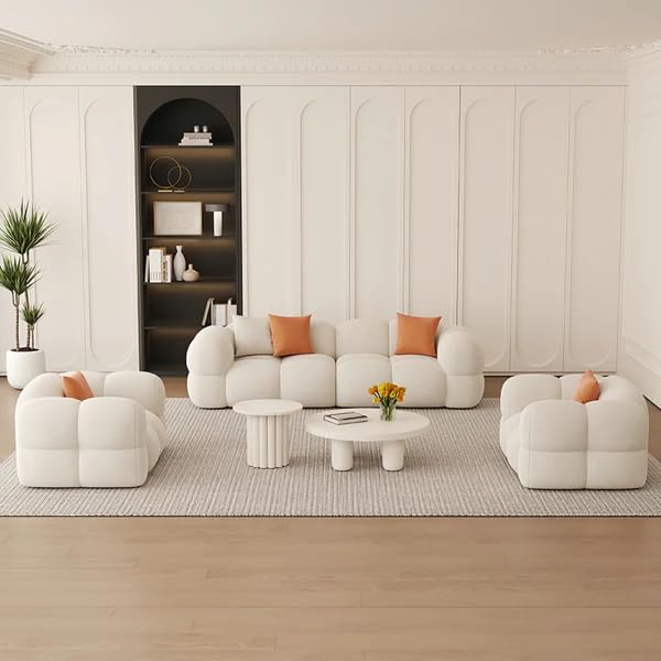 Modern living room with white sofa, armchairs, and a coffee table.