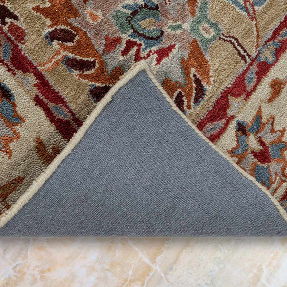 Close-up of a patterned rug with a gray border on a marble floor.