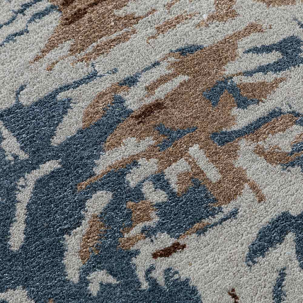 Close-up of a textured rug with abstract pattern in blue, brown, and gray.