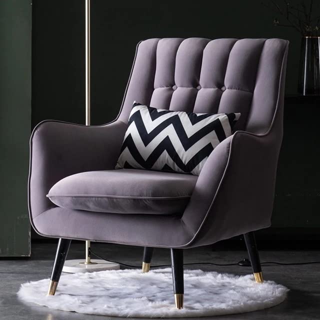 Gray armchair with a black and white chevron pillow on a dark background