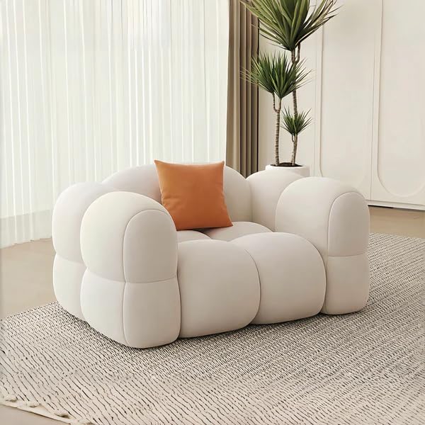 Modern white sofa with an orange pillow in a living room setting