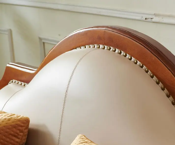 Close-up of a headboard with wooden frame and decorative nailhead trim.