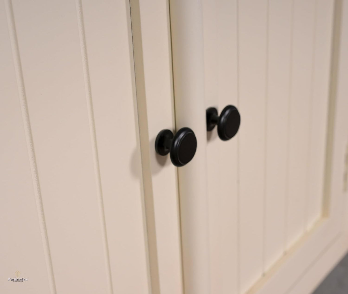 Close-up of a white cabinet with black knobs