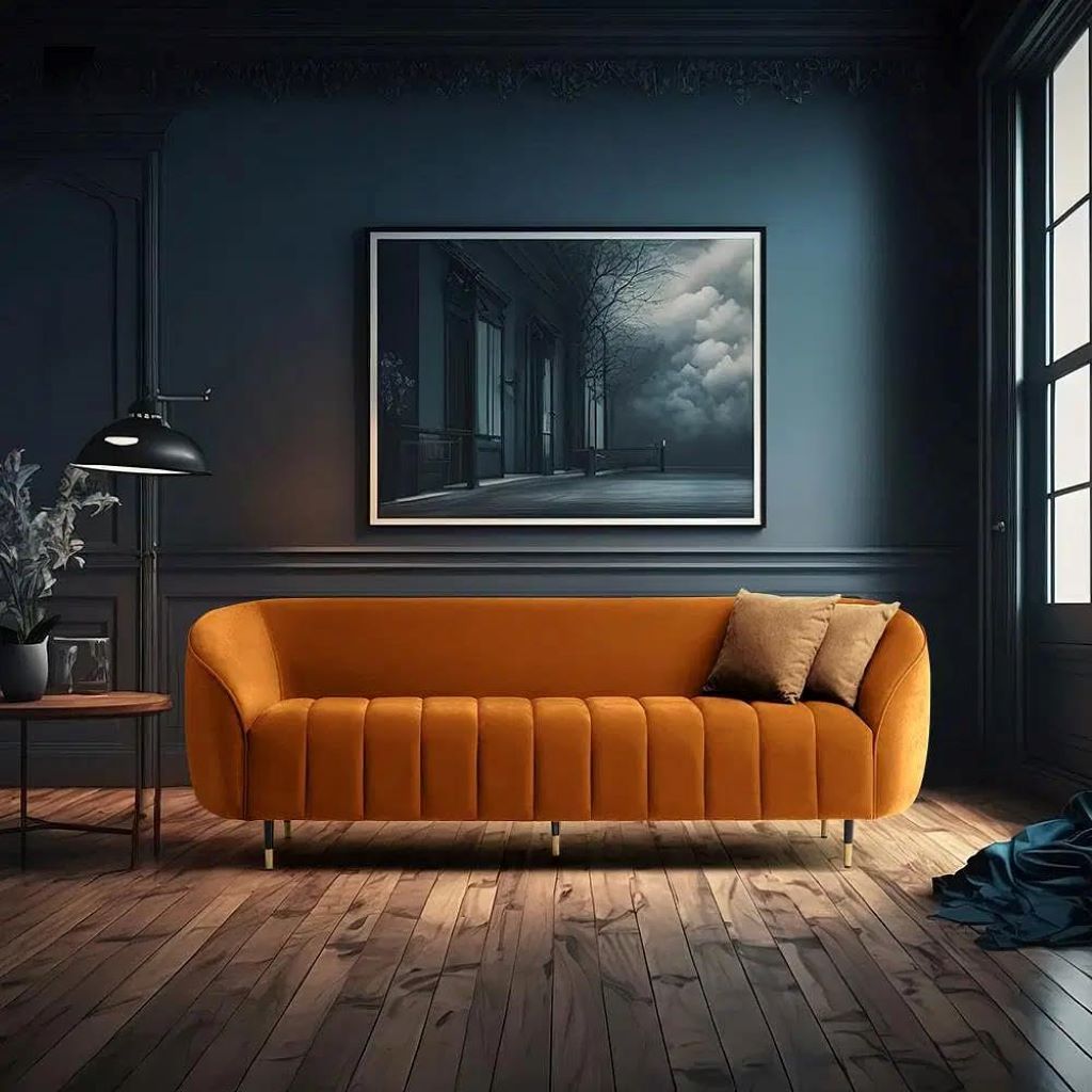 Orange sofa in a room with a dark blue wall and a large framed picture.