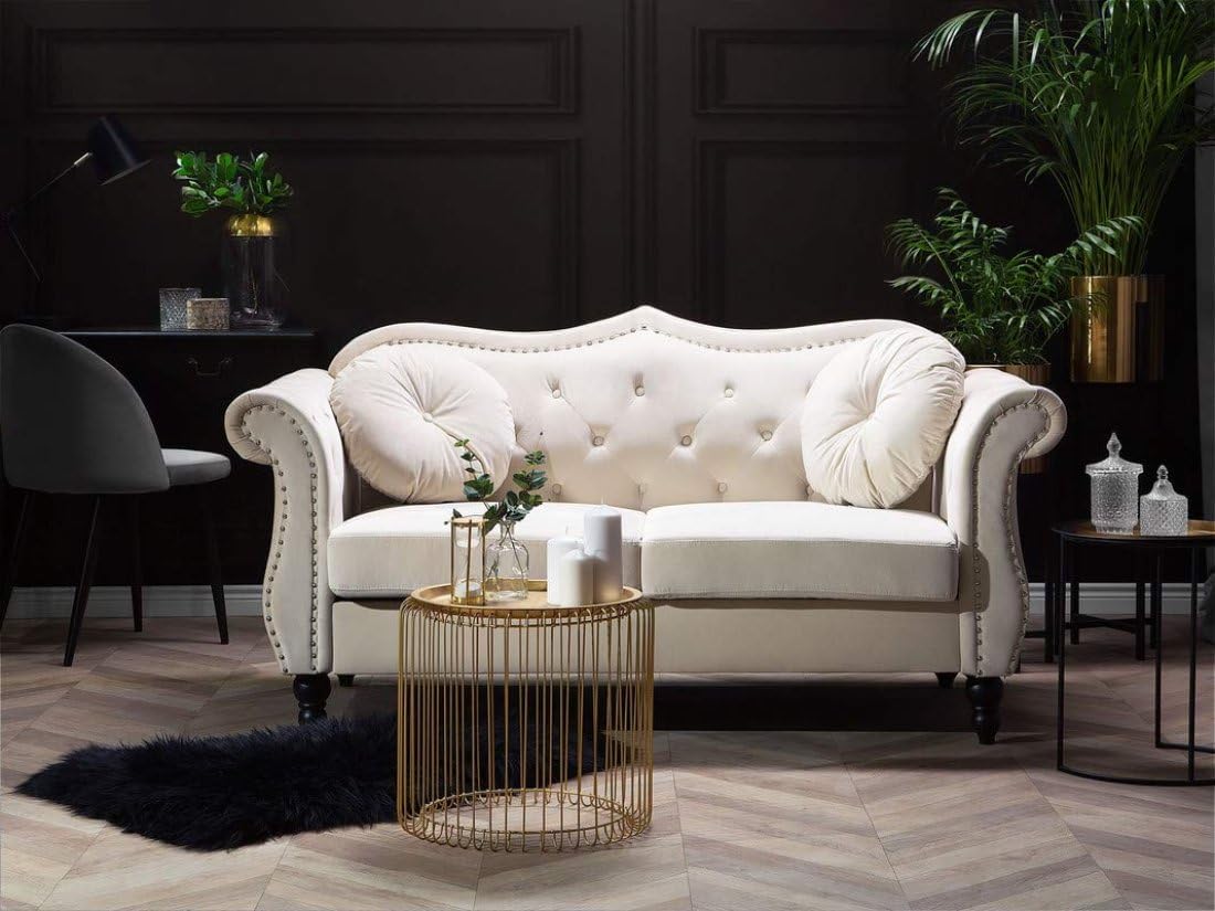 White sofa in a stylish room with a gold side table and decorative items.
