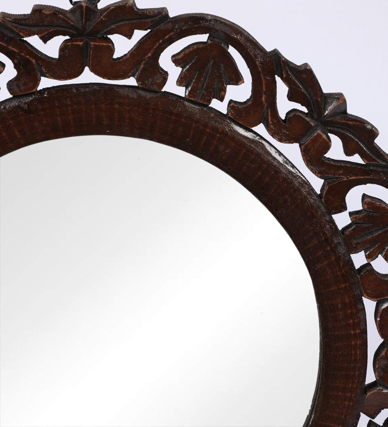 Decorative wooden mirror with intricate carvings on a white background