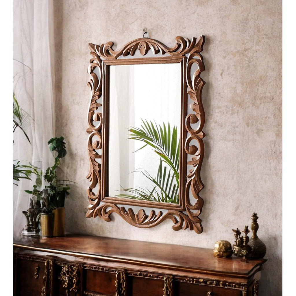 Decorative wooden mirror with intricate carvings on a wall above a wooden console table.