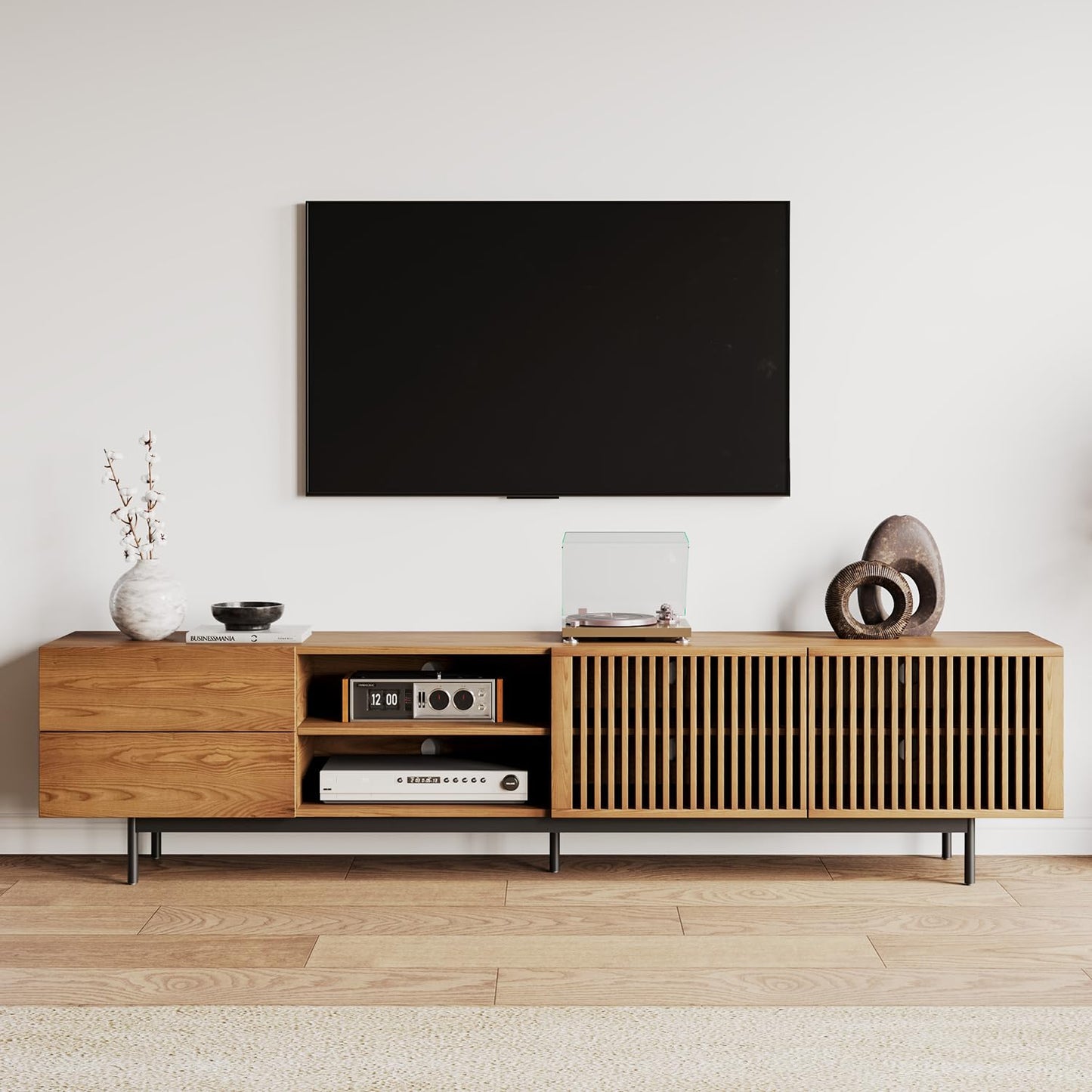 Wooden TV stand with a television mounted on the wall in a minimalistic room.