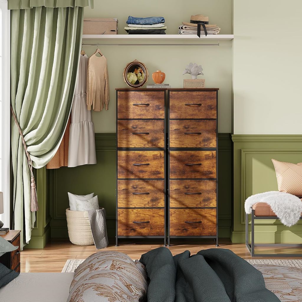 Wooden dresser in a bedroom with green walls and a bed in the foreground.