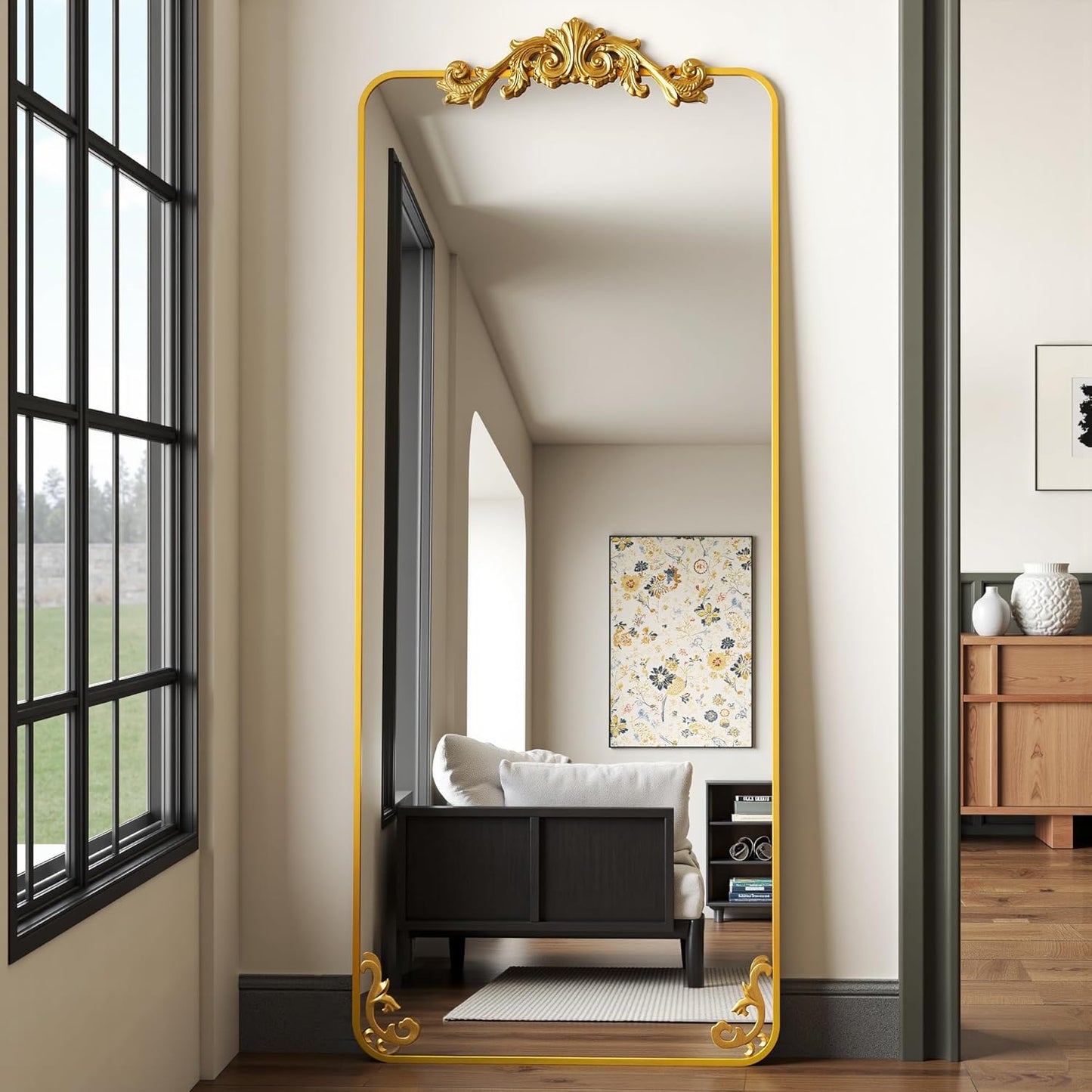 Full-length mirror with gold frame in a room with a bed and window.