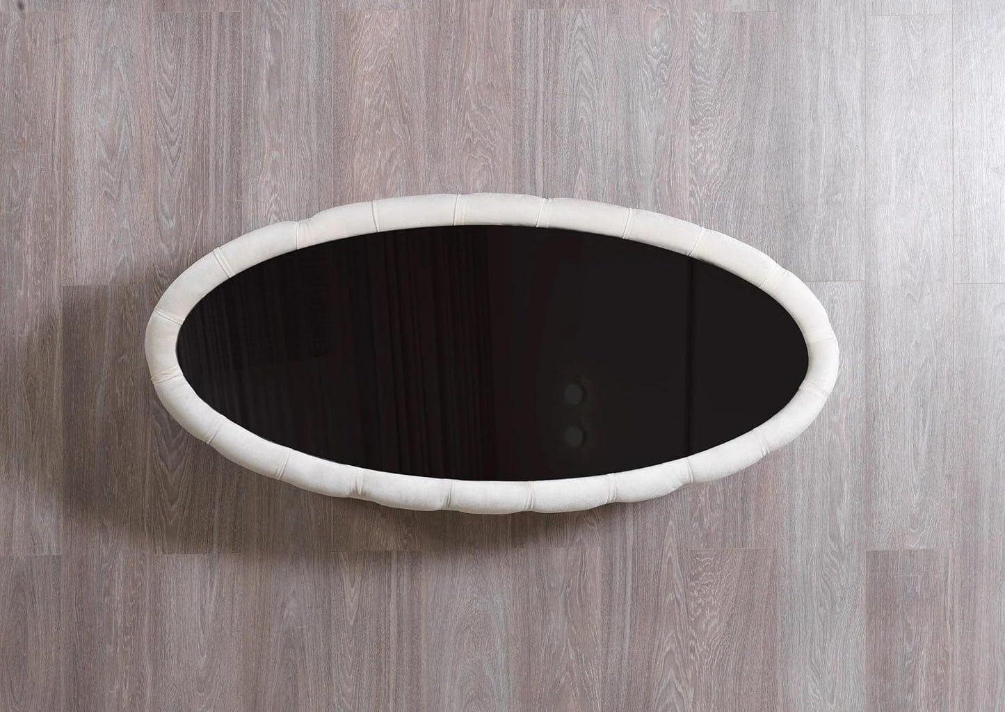 Round black object with white rim on a wooden surface