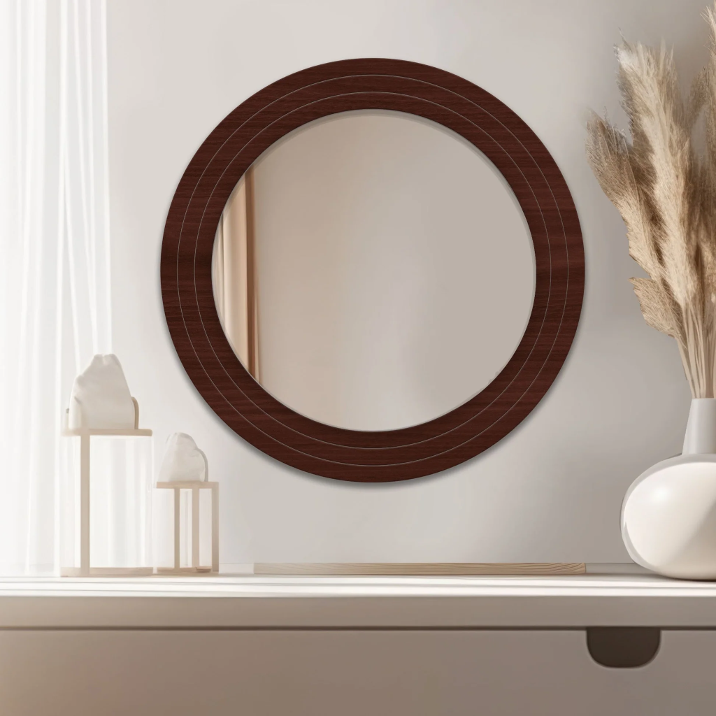 Round mirror with a wooden frame on a wall above a shelf.