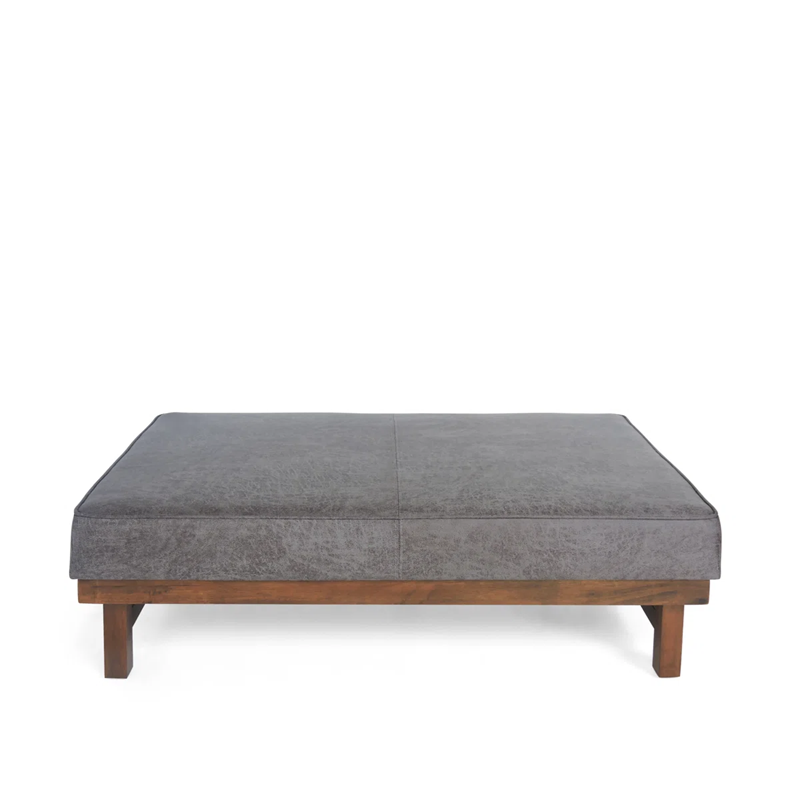 Gray upholstered ottoman with wooden legs on a white background