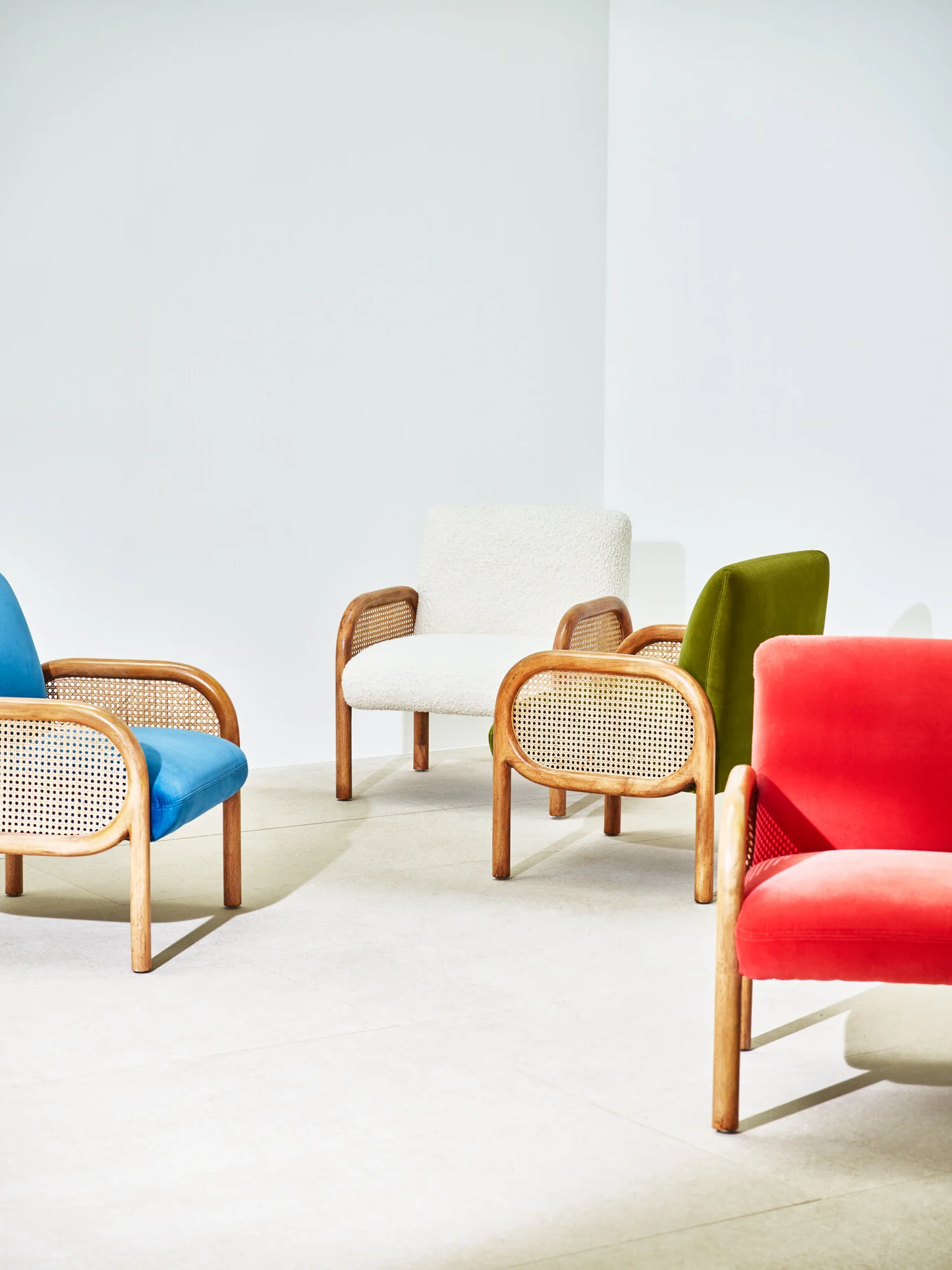 Colorful chairs arranged in a modern interior setting with a white wall.