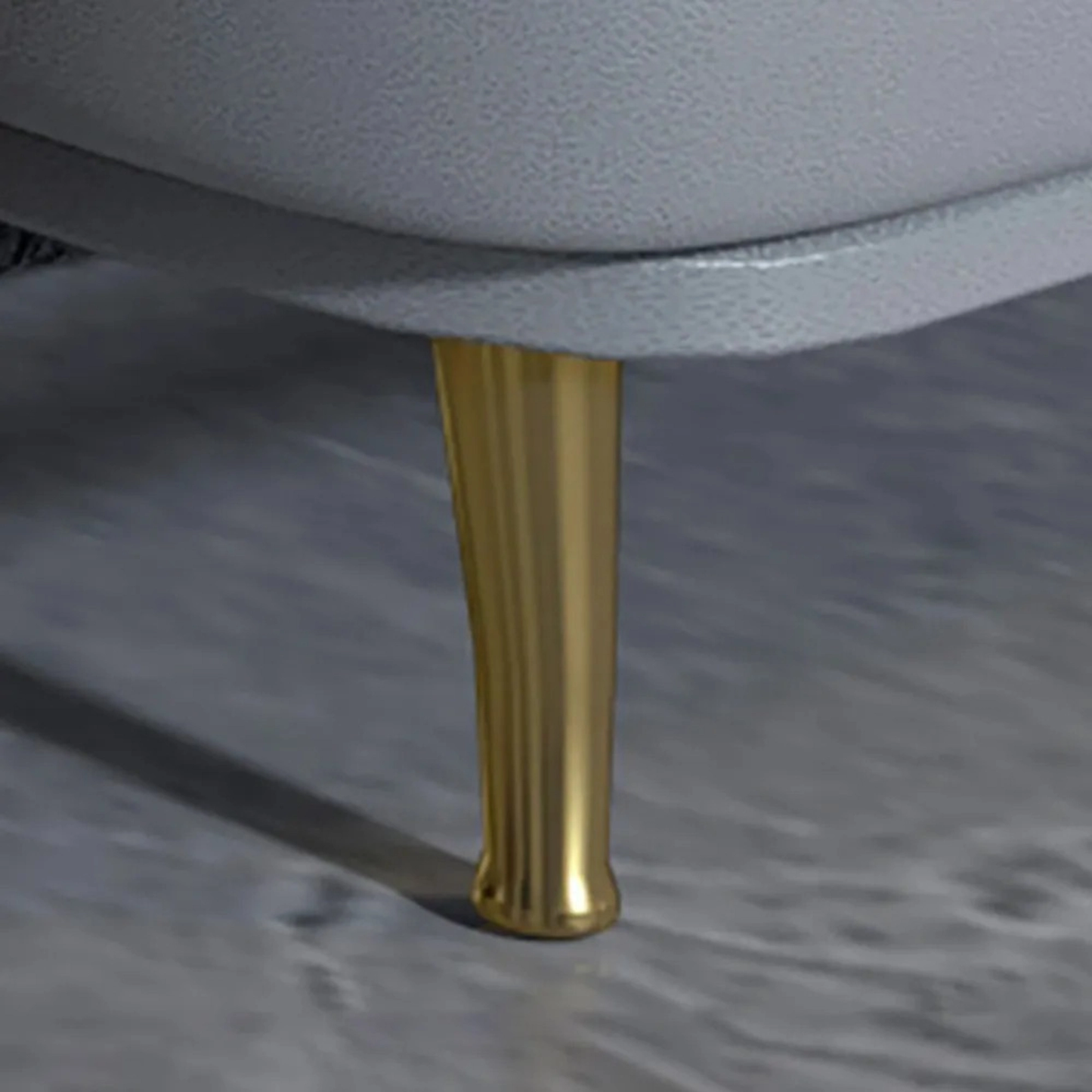 Gold leg of a chair on a gray surface