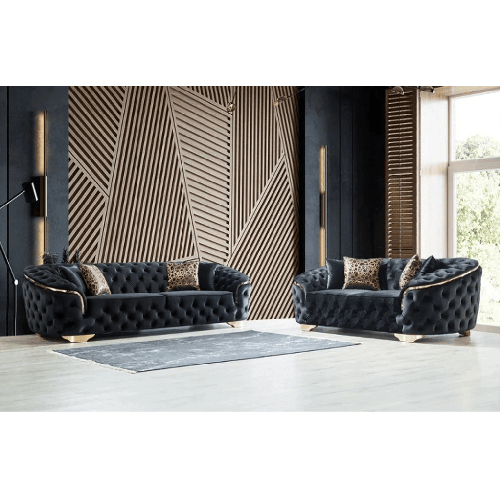 Two dark gray tufted sofas in a modern living room with geometric wall design.