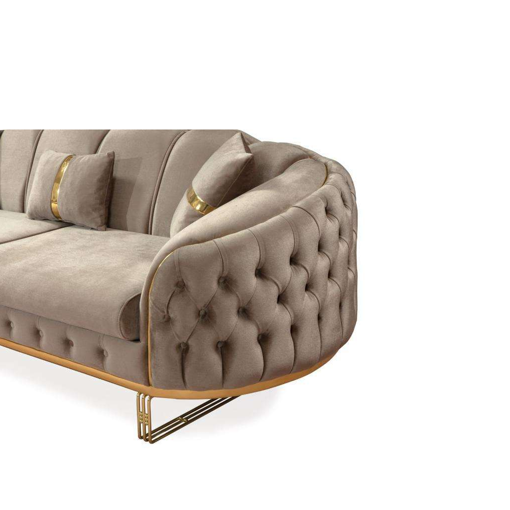 Beige tufted sofa with gold accents on a white background