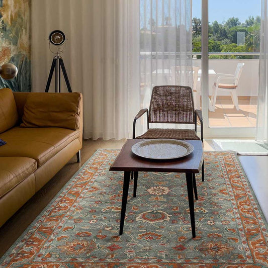 Living room with a brown sofa, patterned rug, and wooden coffee table.