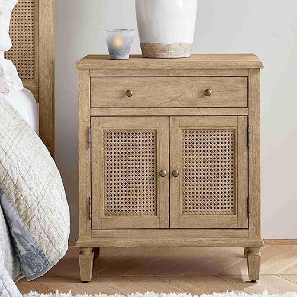 Wooden nightstand with rattan doors next to a bed