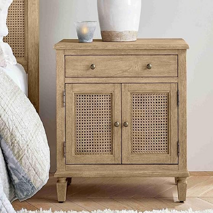 Wooden nightstand with rattan doors next to a bed