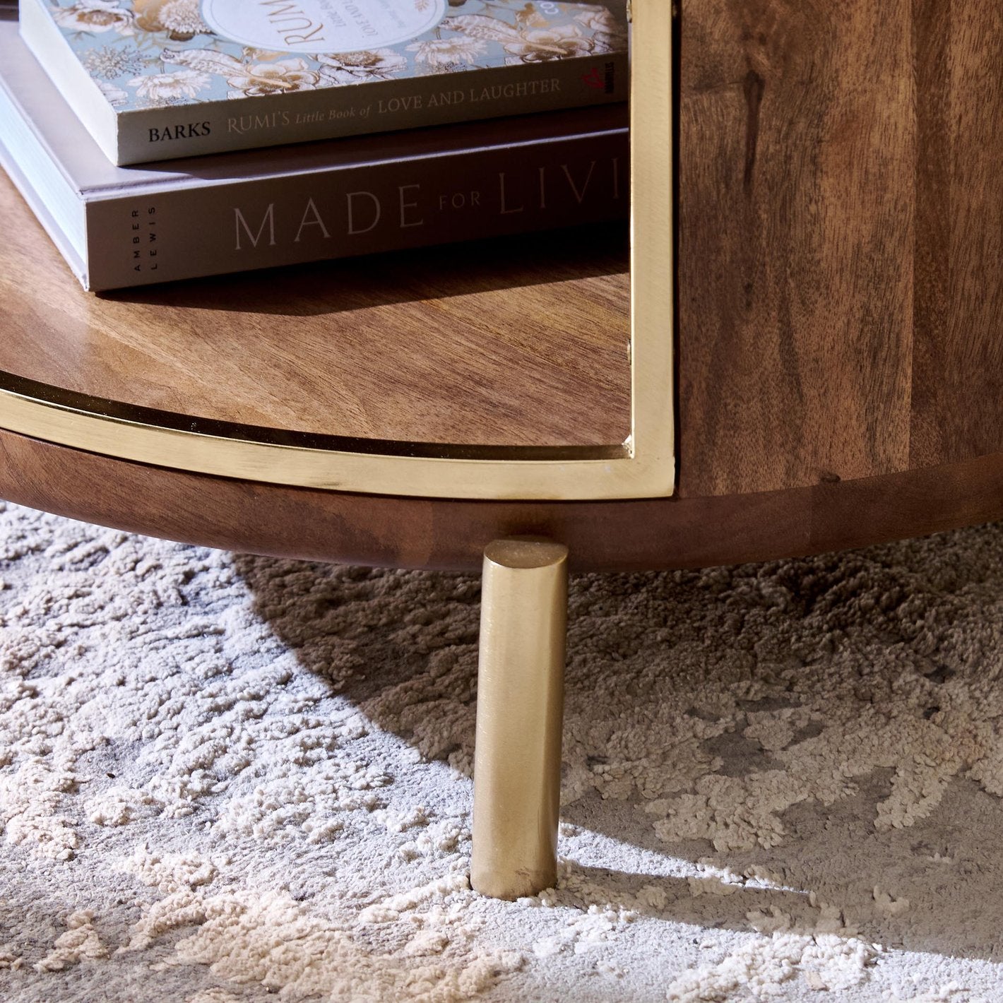 Wooden coffee table with gold legs on a textured surface