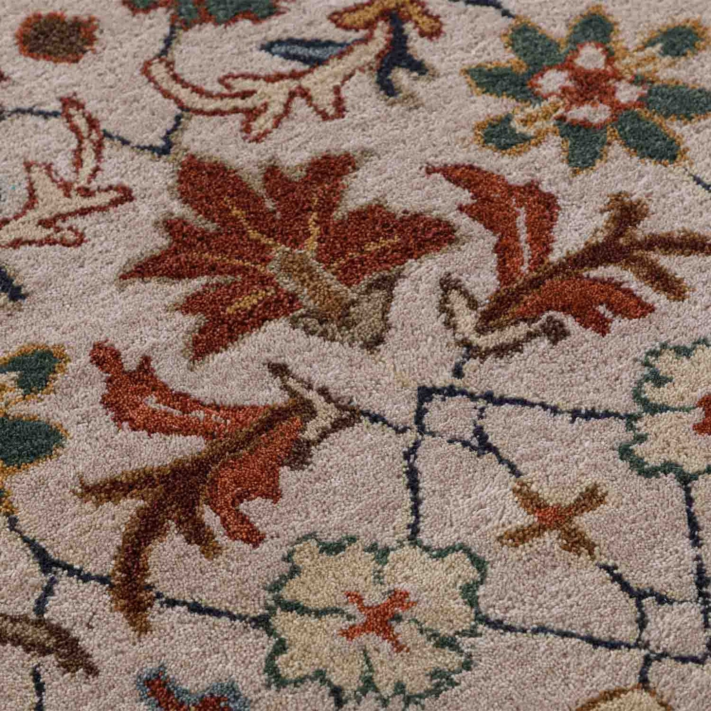 Close-up of a floral-patterned rug with brown, red, and beige colors.