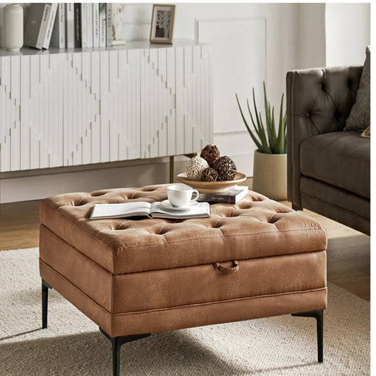 Brown tufted ottoman in a living room setting with a coffee table and decor items.