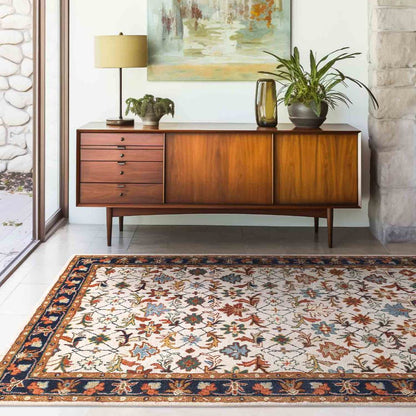 Wooden sideboard with decorative items in a room with a patterned rug.