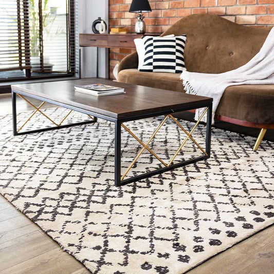 Living room with a brown sofa, coffee table, and patterned rug.