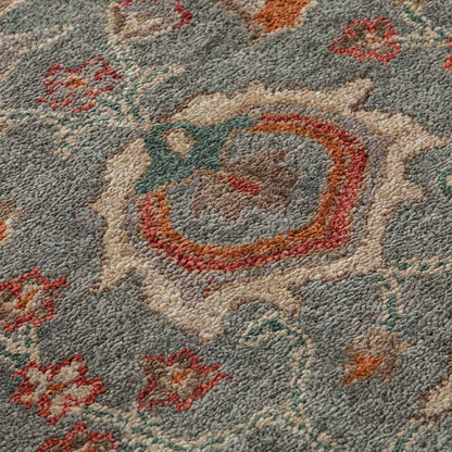 Close-up of a patterned rug with floral designs and a central circular design.