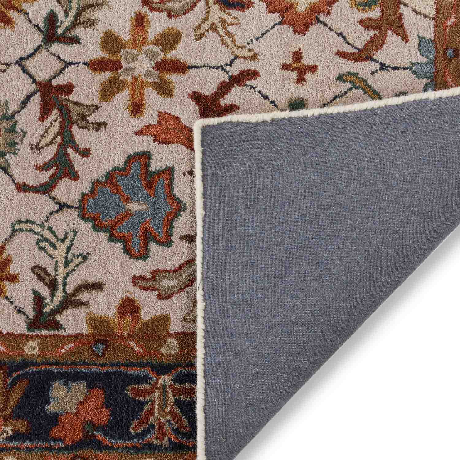 Close-up of a patterned rug corner with a gray underlay.