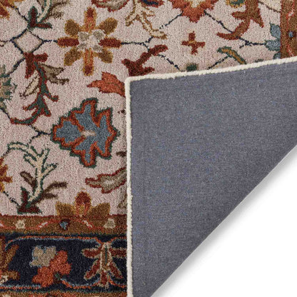 Close-up of a patterned rug corner with a gray underlay.