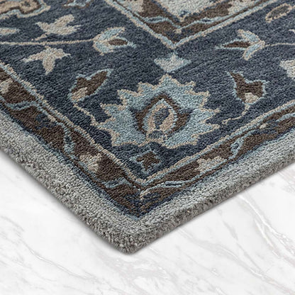 Close-up of a blue and gray patterned rug on a white floor.