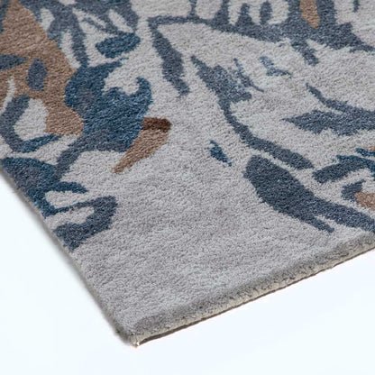 Close-up of a patterned rug with blue, brown, and gray colors on a white background.