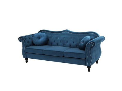 Blue sofa with tufted backrest and nailhead trim on a white background