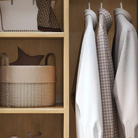 Clothing hanging on a rack next to wooden shelves with a basket and folded garment.