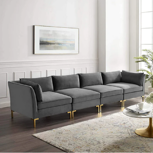 Gray sectional sofa in a living room with a painting on the wall and a small table.