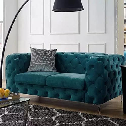 Teal tufted sofa with a decorative pillow in a living room setting.