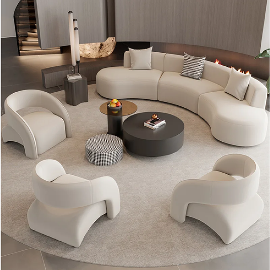 Modern living room with a curved beige sofa, white armchairs, and a round coffee table.