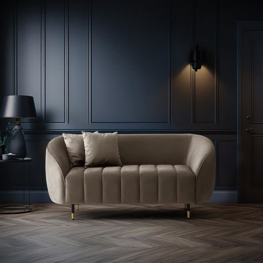 Beige sofa in a dark room with a lamp and decorative items.
