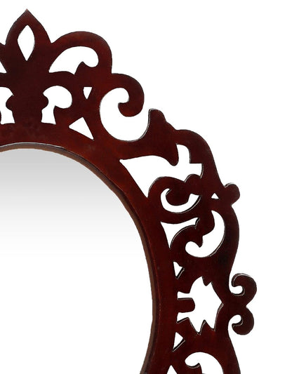 Decorative mirror with intricate brown frame on a white background