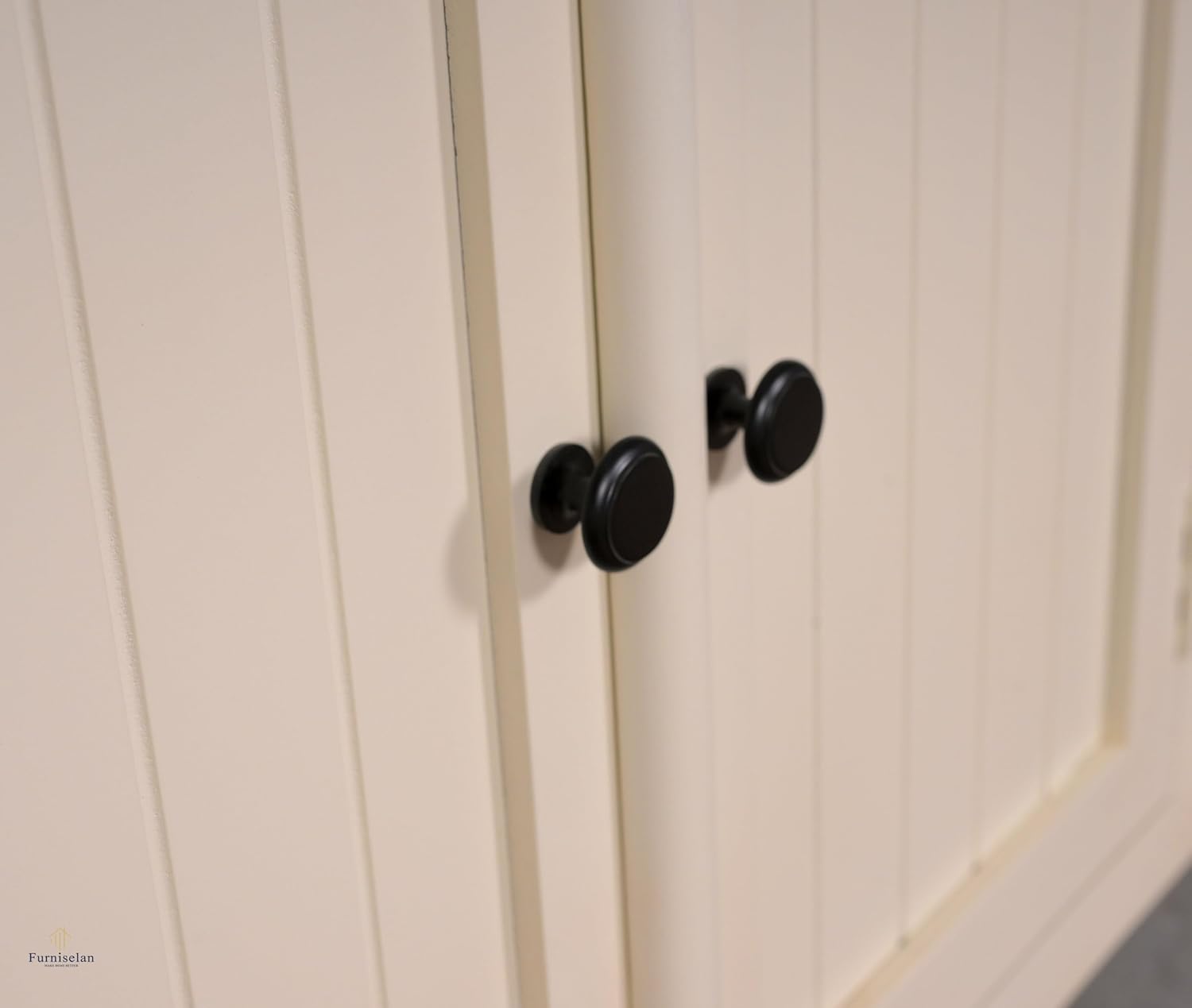 Close-up of a white cabinet with black knobs