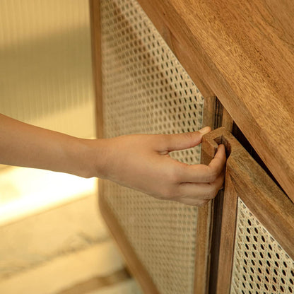 Hand opening a wooden cabinet with woven design