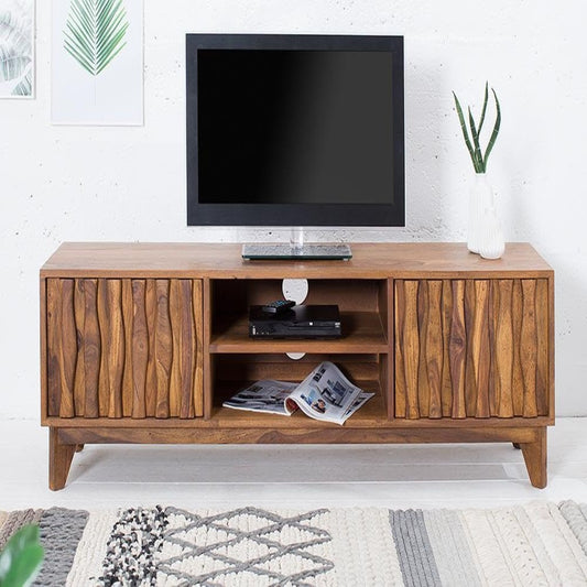 Wooden TV stand with a television on top in a room setting.